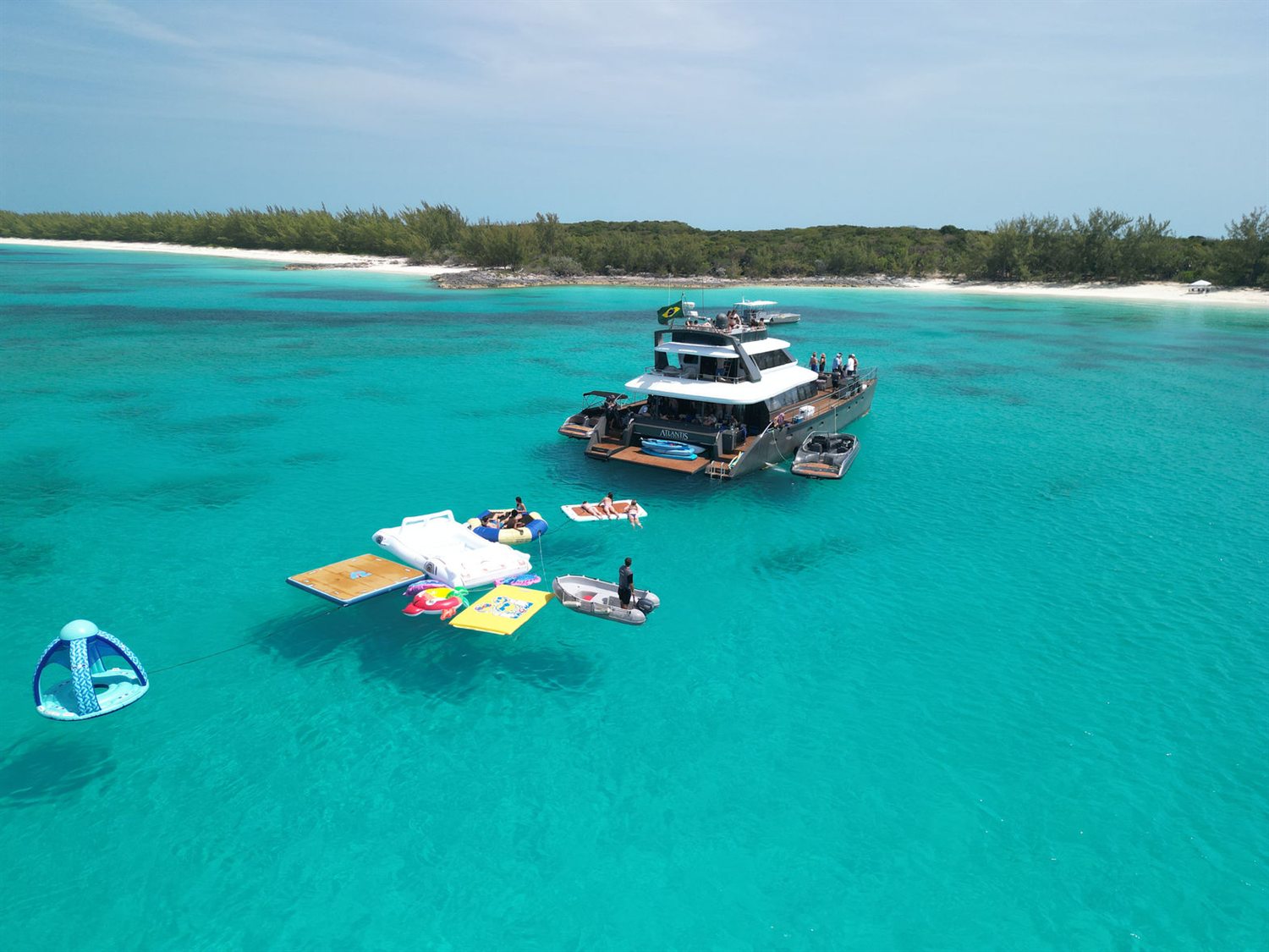The 80ft Atlantis II catamaran in the Bahamas anchored off a beach with floating platforms alongside