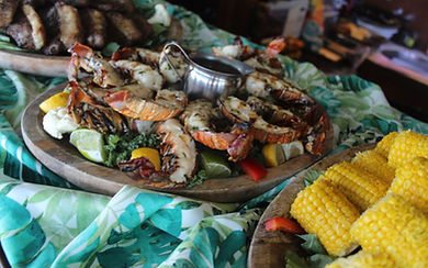 Platter of grilled lobster and seafood at a beach set up for a charter group