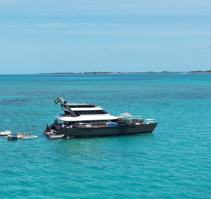 The 80ft Atlantis II catamaran lying at anchor in open turquoise water in the Bahamas