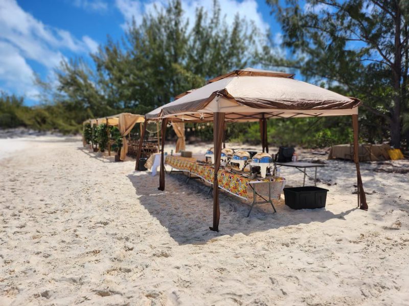 Shaded beach barbecue set up on the sand for an 80ft Atlantis II catamaran charter group