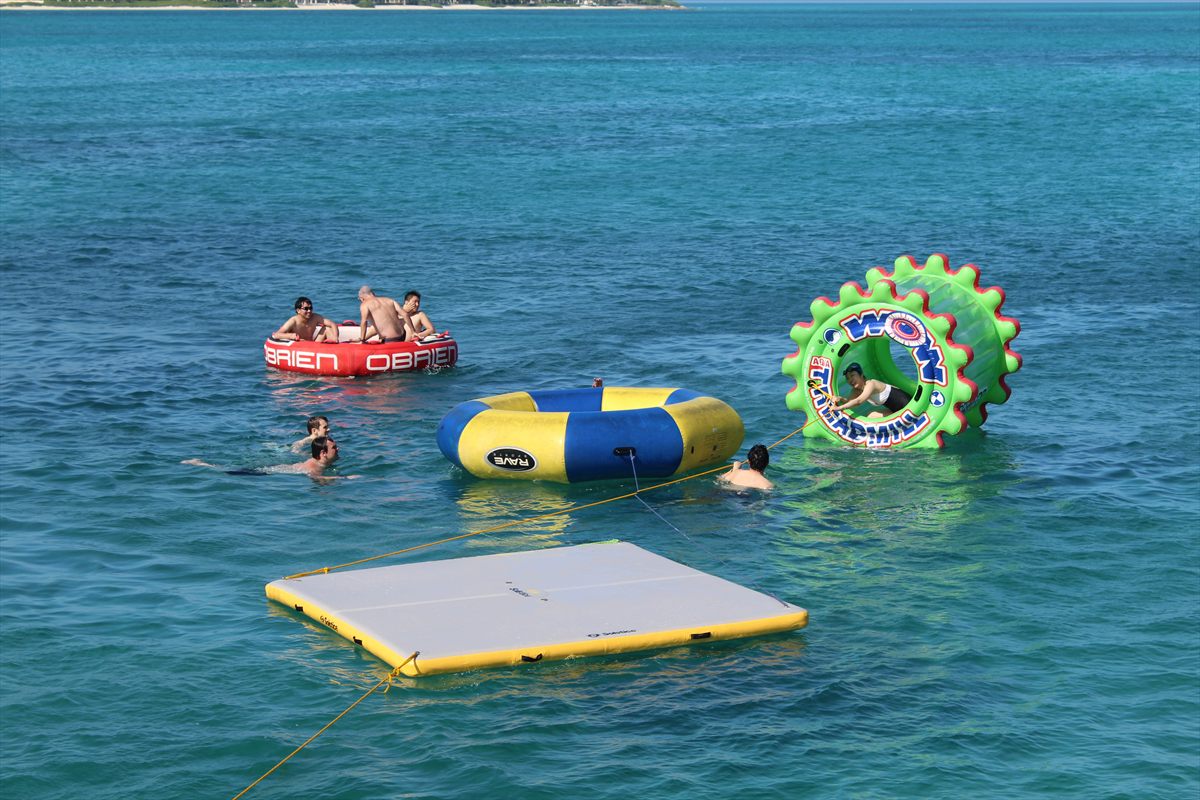 Plataformas flotantes y juguetes acuaticos junto a un barco de charter