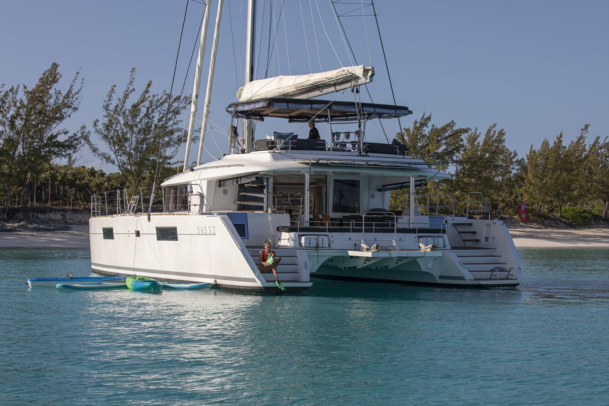 Catamaran anchored off a beach in clear Bahamian water