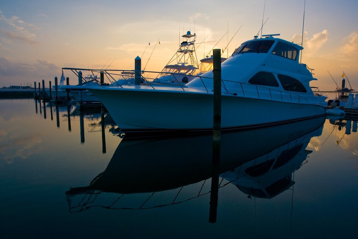 Sportfishing boat with a tuna tower and outriggers at a Bahamas marina at dawn
