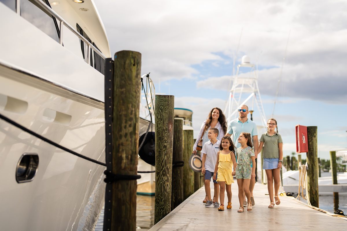Charter guests on the dock beside a yacht in the Bahamas