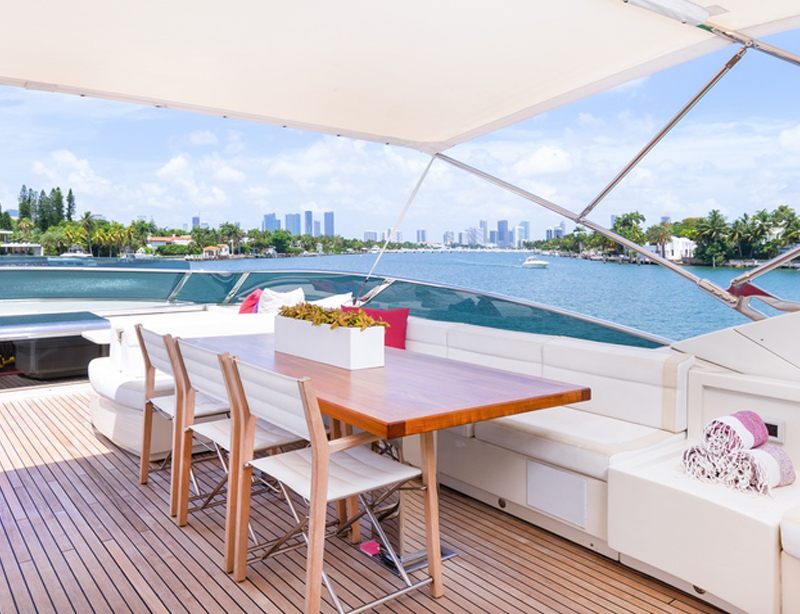 Flybridge dining table of the 100 Dominator shaded beneath a white awning