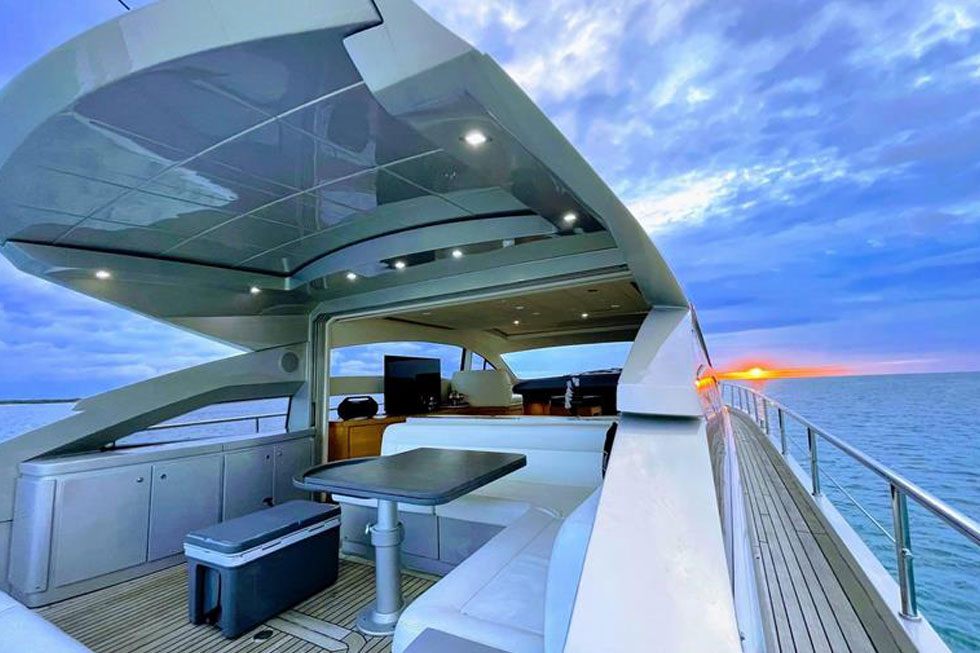 Aft deck of the 64 Pershing set for dinner beneath her glass hardtop at dusk