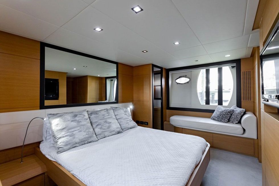 Guest cabin aboard the 64 Pershing with a double berth and portholes
