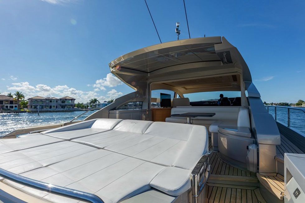 Bow sun pad of the 64 Pershing with waterfront homes behind