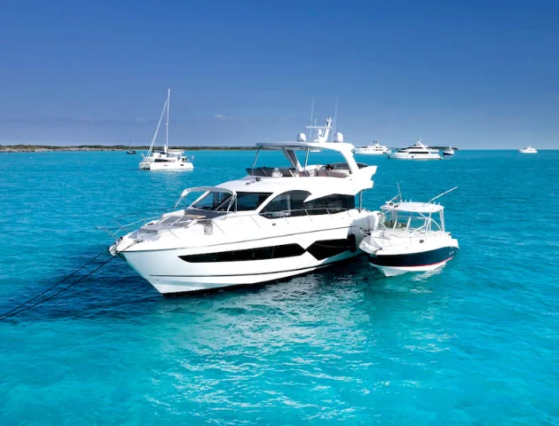 The 68 Sunseeker Manhattan at anchor in clear turquoise water with a low cay beyond