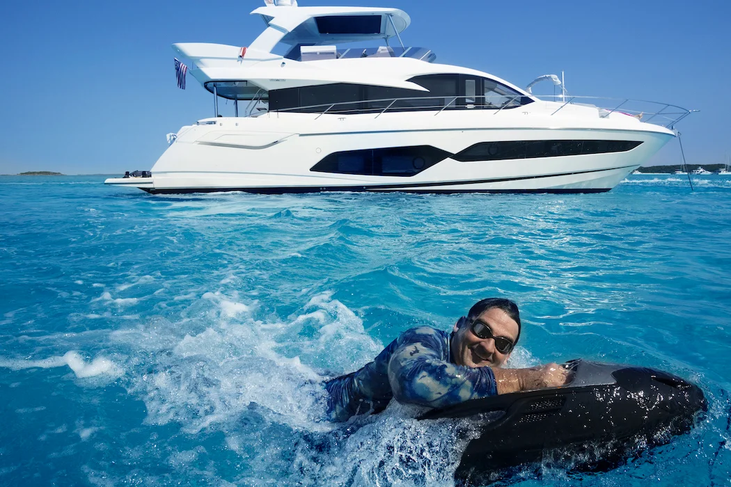 Guest riding a seabob through the water with the 68 Sunseeker Manhattan anchored behind