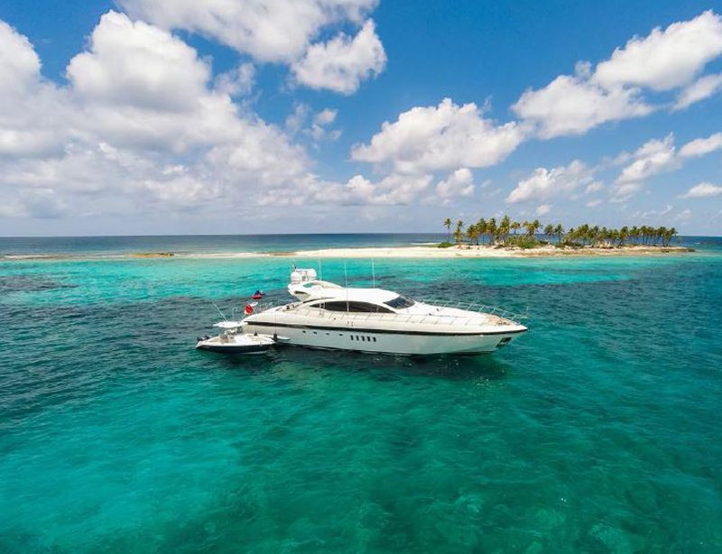 Aerial view of the 92 Mangusta anchored off a small palm covered island in turquoise water