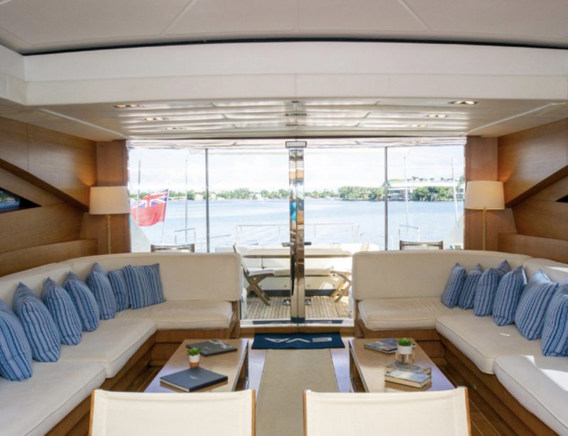 Salon of the 92 Mangusta with pale seating, striped cushions and a dining area